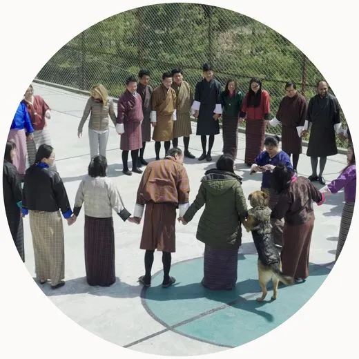 Teachers in a wellbeing circle on a court in Bhutan